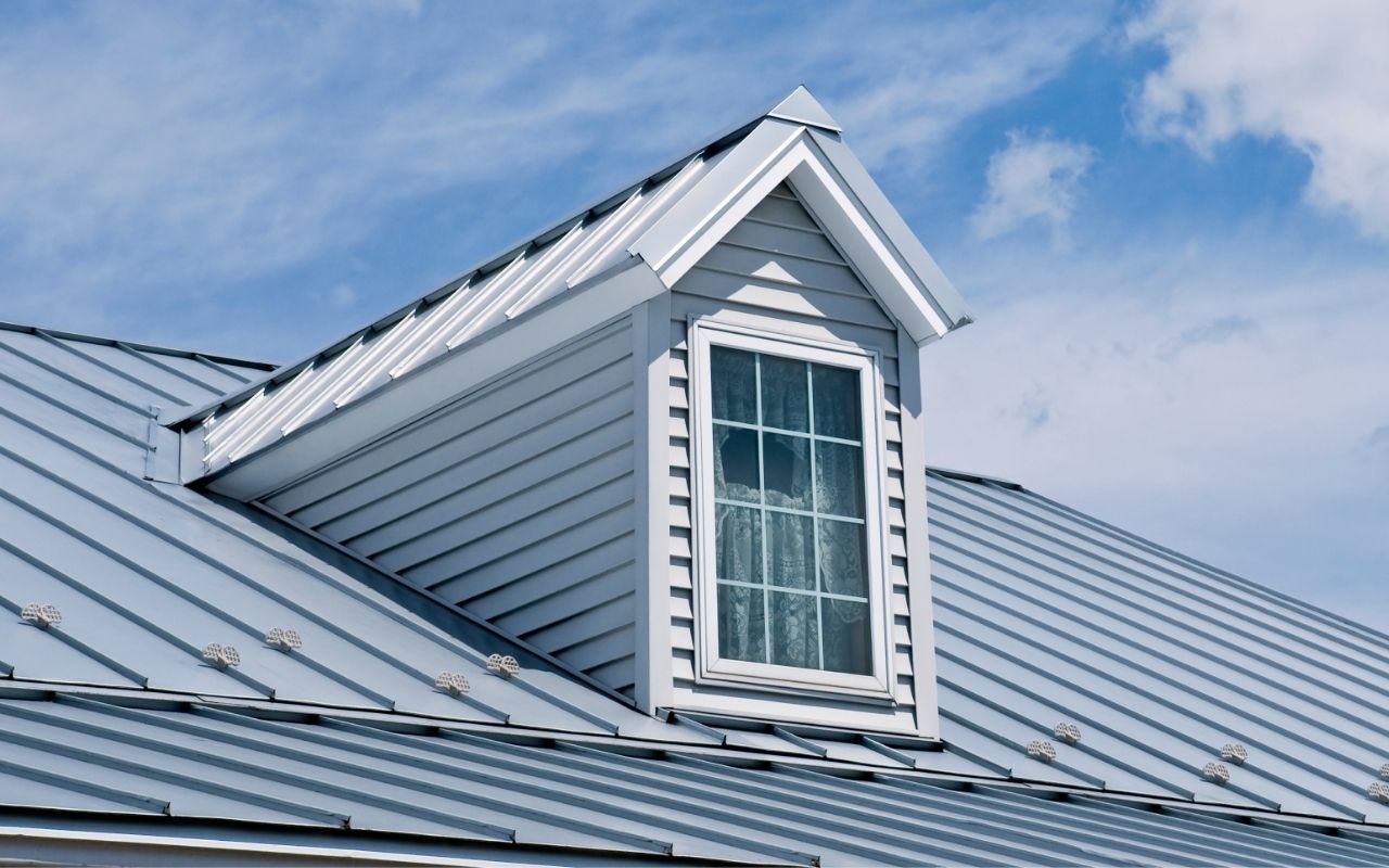 House with a light-colored roof reflecting sunlight during summer
