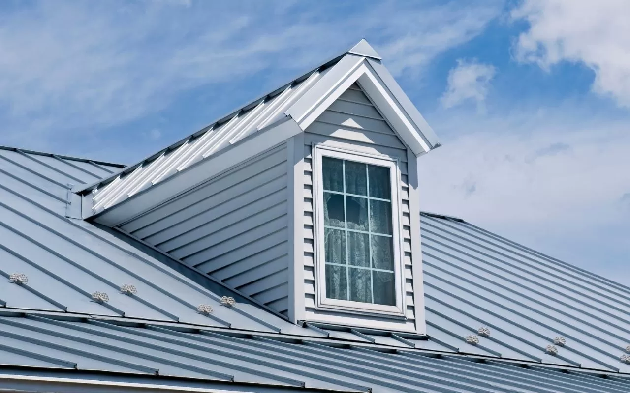 House with a light-colored roof reflecting sunlight during summer